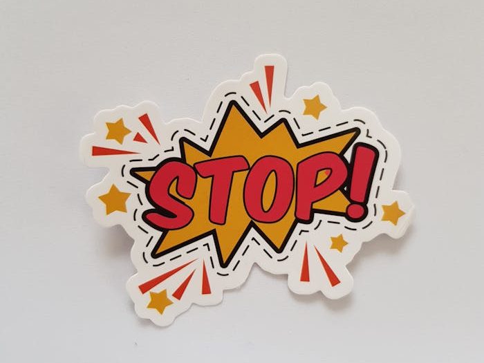 Bright and colorful sticker design featuring a comic-style Stop! sign on a gray background.